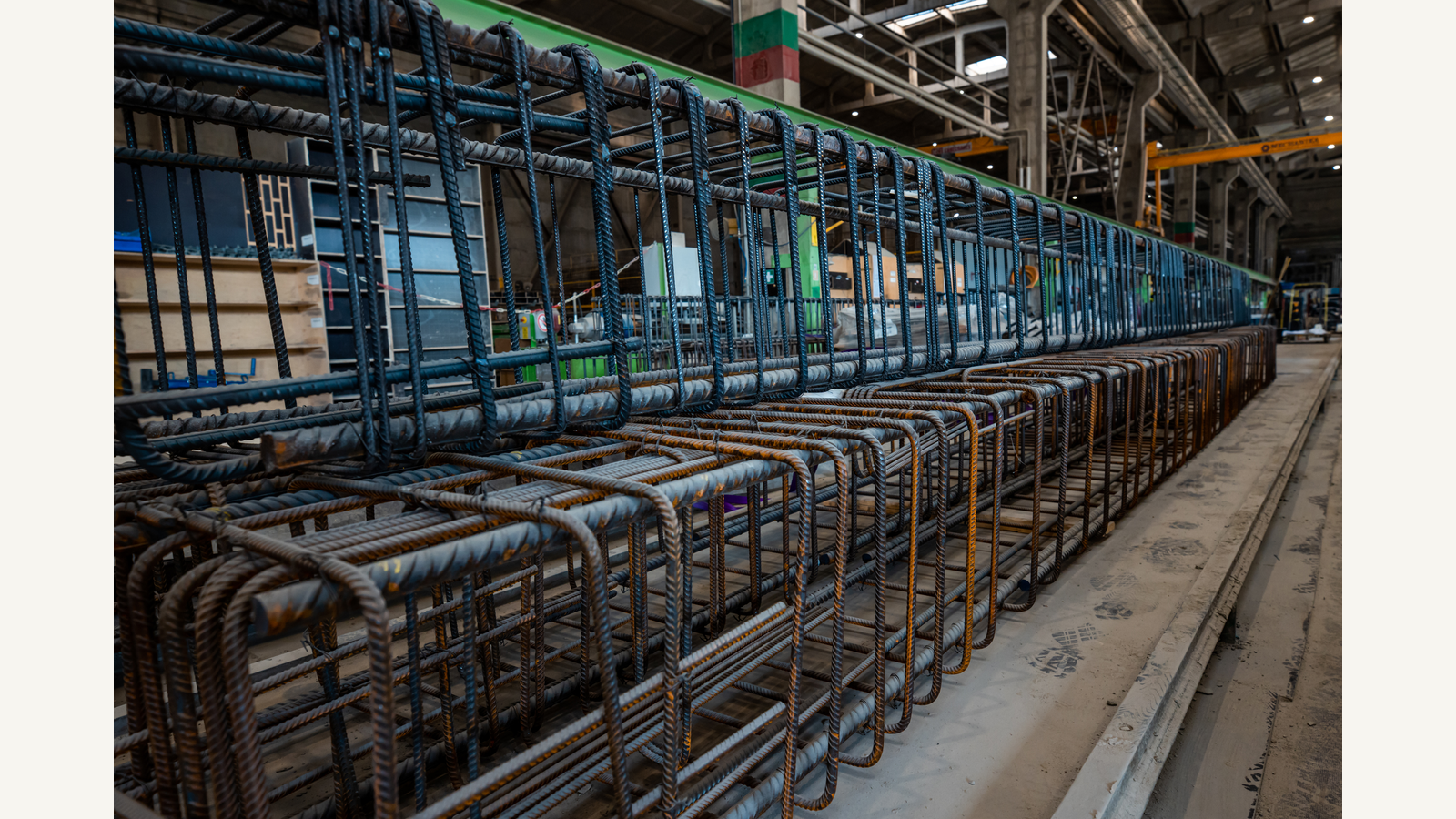 Illustration of steel reinforcement bars stored inside an industrial warehouse.