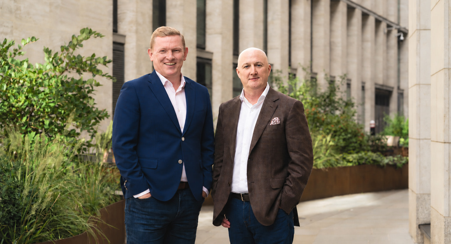 John Butler, in a blue jacket, stands beside Paul Boylan, in a brown jacket
